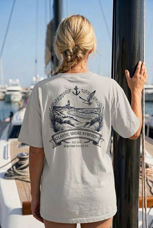 Graumeliert maritimes Organic Oversized T-Shirt mit großem Rückenmotiv „Atlantic Shore Symphony“, Leuchtturm in den Dünen, schwungvollem Notenband, Anker und Möwe (Heather Gray) www.digiuliano.com